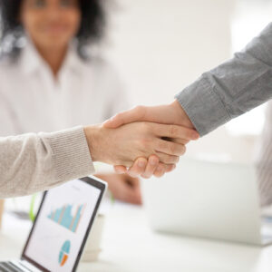 Business partners handshaking at group meeting making project in