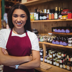 Portrait of female staff standing with arms crossed in super market