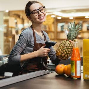 Happy female cashier scanning grocery items