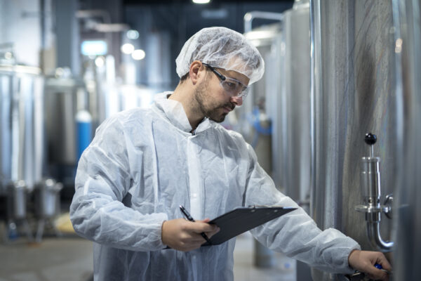 Shot of middle aged concentrated technologist worker controlling production in pharmaceutical or chemical industry.